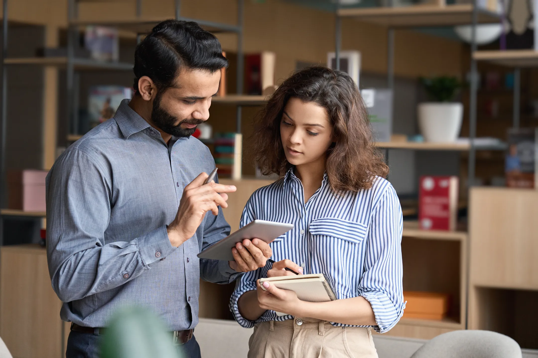 young female intern discussing to-do list with boss